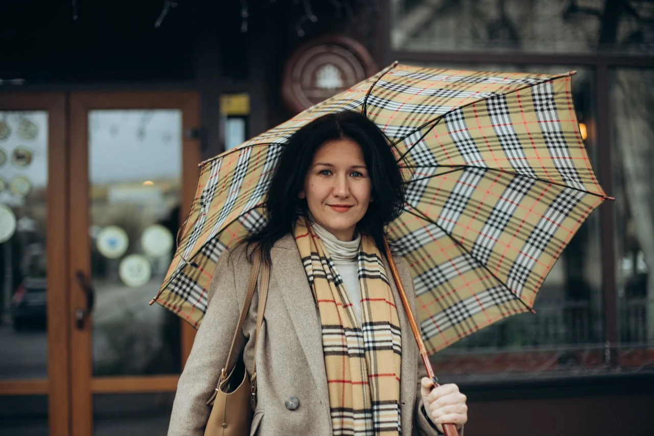 Психотерапевт Тетяна Колосова стоїть під парасолькою та посміхається.