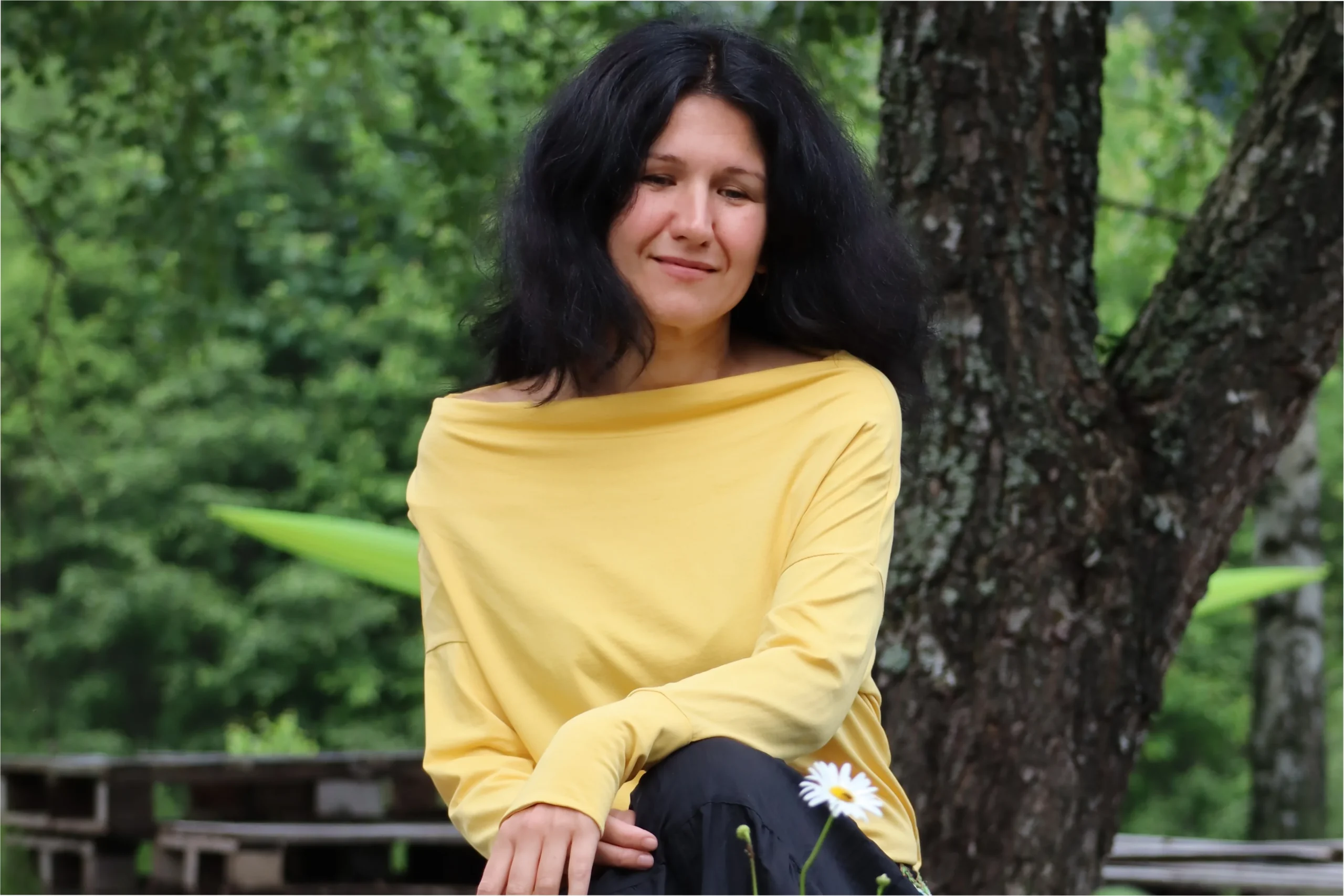 Психотерапет Татьяна Колосова сидит возле дерева.